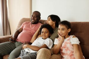 happy family sitting on a couch and watching tv