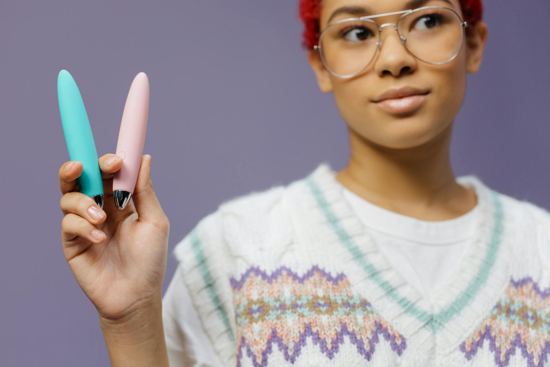 a woman in knitted sweater vest holding a vibrators