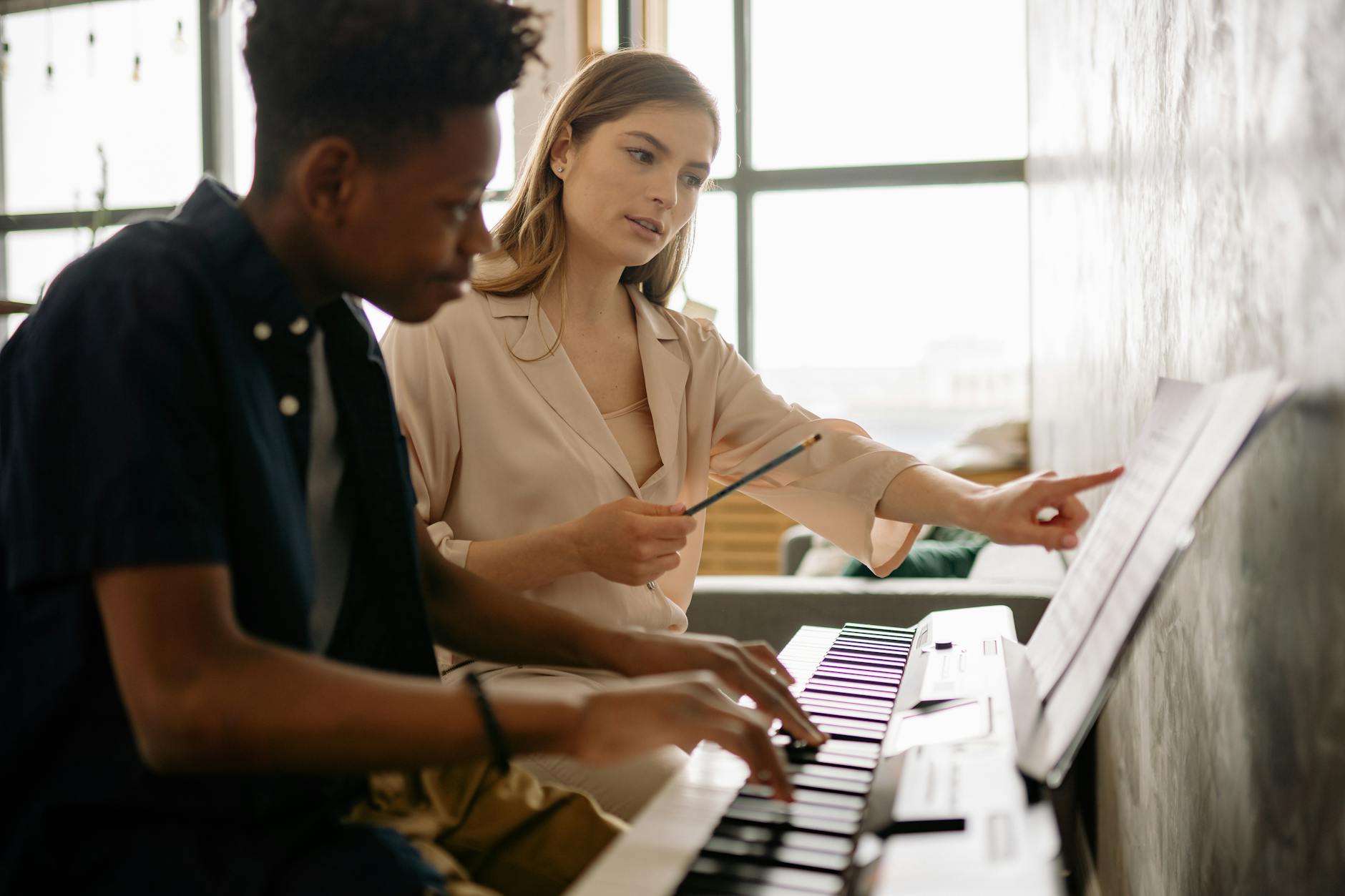 a woman teaching a boy while looking at musical notes